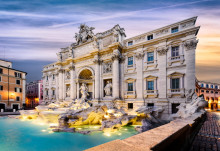 the majestic trevi fountain in the center of piazza di trevi, italy at sunrise. the marble architecture is illuminated by golden light, and water splashes can be seen from under the sculptures.